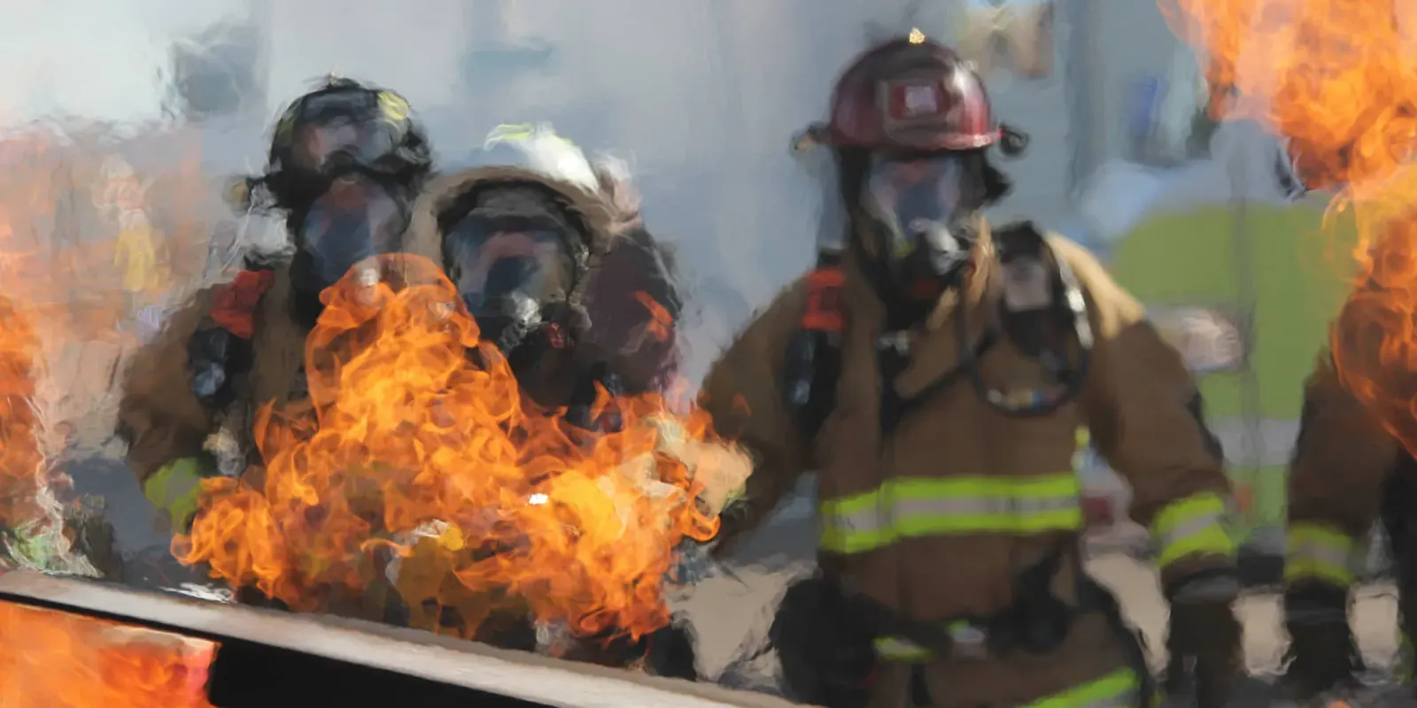 Feuerwehrleute im Einsatz vor Flammen
